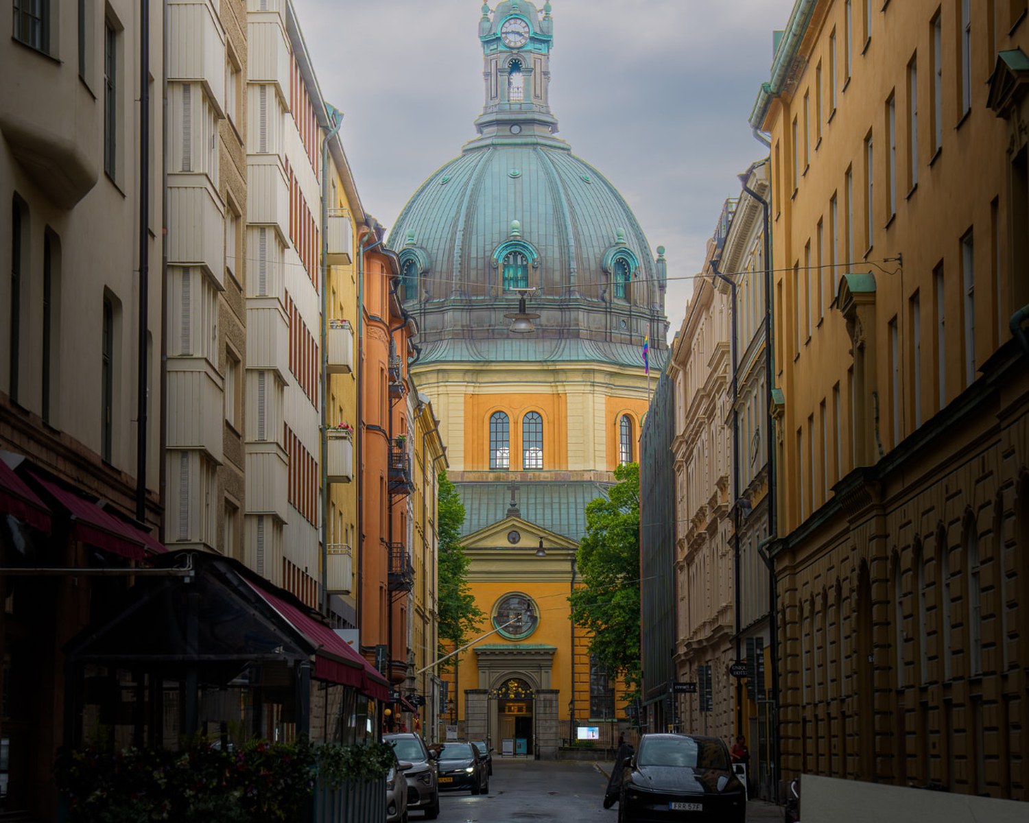 Gatuvy i Stockholm med Hedvig Eleonora kyrkas gröna koppar kupol i mjukt kvällsljus